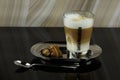 A glass of latte macchiato on a plate with a plate of cookies. Royalty Free Stock Photo