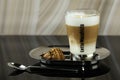 A glass of latte macchiato on a plate with a plate of cookies. Royalty Free Stock Photo