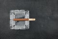 Glass ashtray and cigar on a black natural leather