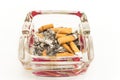 Glass ashtray with cigarette butts, isolated on white Royalty Free Stock Photo