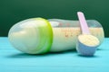 Glass baby bottle with powdered milk and a scoop nearby Royalty Free Stock Photo