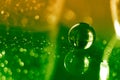Glass ball on a glass table with reflection on green yellow background. Beautiful bokeh. Art work