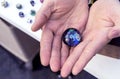 Glass ball with the image of the universe, stars and planets in the hands of man. The concept of a fragile world