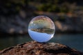 Glass ball lying on a rusty bollard