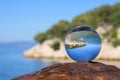 Glass ball lying on a rusty bollard