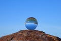 Glass ball lying on a rusty bollard