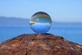 Glass ball lying on a rusty bollard