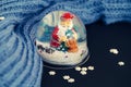 Glass ball with Santa Claus figurine and snowflake sequins, warm winter scarf and Christmas decoration Royalty Free Stock Photo