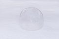 glass ball or transparent bauble on white snow. winter outdoors. brilliant sphere snowy background.