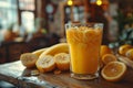 A glass of banana and orange juice rests on a wooden table