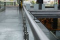 Glass barrier with metal handrail in modern building, closeup