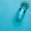 Water glass with strong shadows on white background