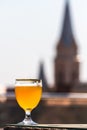 A glass of beer against the background of old buildings