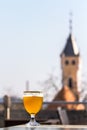 A glass of beer against the background of old buildings