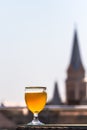 A glass of beer against the background of old buildings