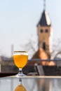 A glass of beer against the background of old buildings