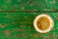 A glass of beer with alcohol. Golden, intoxicating drink in a transparent mug, stands on a wooden stand in the rays of daylight.