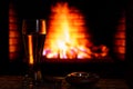 A glass of beer, an ashtray with a cigar on the background of the fireplace.