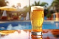 Glass of beer on the background of the pool and palms. Royalty Free Stock Photo