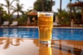 Glass of beer on the background of the pool and palms. Royalty Free Stock Photo