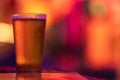 A glass of beer on the bar in a bright colorful setting Royalty Free Stock Photo