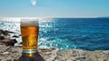 Glass of beer on the beach with sea and sky in the background Royalty Free Stock Photo