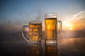 Glass of beer on a beach at sunset. Cooling summer drink concept. Close Up of A Glass of Draught Beer with the Bokeh of Sunlight Royalty Free Stock Photo