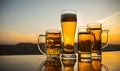 Glass of beer on a beach at sunset. Cooling summer drink concept. Close Up of A Glass of Draught Beer with the Bokeh of Sunlight Royalty Free Stock Photo