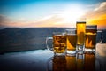 Glass of beer on a beach at sunset. Cooling summer drink concept. Close Up of A Glass of Draught Beer with the Bokeh of Sunlight Royalty Free Stock Photo