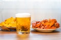 A glass of beer , boiled crayfish and a plate of nachos chips on the table Royalty Free Stock Photo