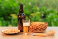 Glass of beer and bottle of beer on wooden table with potato chi Royalty Free Stock Photo