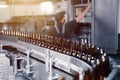 Glass beer bottles of brown color on the conveyor line of beer bottling close up. Royalty Free Stock Photo