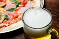 Glass of beer close up on pizza background Royalty Free Stock Photo