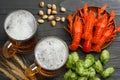 Glass beer with crawfish, hop cones and wheat ears on dark wooden background. Beer brewery concept. Beer background. top view Royalty Free Stock Photo