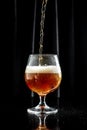 Glass of beer on dark background. beer being poured into glass Royalty Free Stock Photo