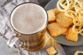 Glass of beer with foam and onion rings and a cracker , drink with snacks Royalty Free Stock Photo