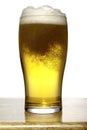 Glass of beer with foam on wood and white background Royalty Free Stock Photo