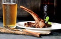 A glass of beer, fried lamb chops with garlic and other spices