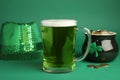 Glass of beer, gold and party hat on green background. St Patrick`s Day celebration Royalty Free Stock Photo