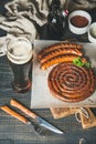 Glass of beer and grilled sausages on wooden serving board Royalty Free Stock Photo