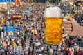 Glass of beer holding in hand at Oktoberfest in Munich Royalty Free Stock Photo