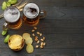 Glass beer with hop cones, pistachio and wheat ears on dark wooden background. Beer brewery concept. Beer background. top view Royalty Free Stock Photo