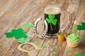 Glass of beer, horseshoe, green cupcake and coins Royalty Free Stock Photo