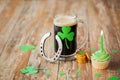 Glass of beer, horseshoe, green cupcake and coins Royalty Free Stock Photo