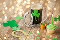 Glass of beer, horseshoe, green cupcake and coins Royalty Free Stock Photo