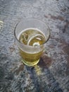 A glass of beer with ice on wood background