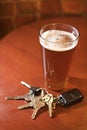 Glass of Beer and Keys on Bar Table Royalty Free Stock Photo