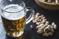 Glass of beer and peanuts on the wooden background Royalty Free Stock Photo