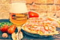 Glass of beer and pizza with salami on background Royalty Free Stock Photo