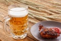 Glass of beer, plate with grilled chicken and ears of barley on a wooden background Royalty Free Stock Photo